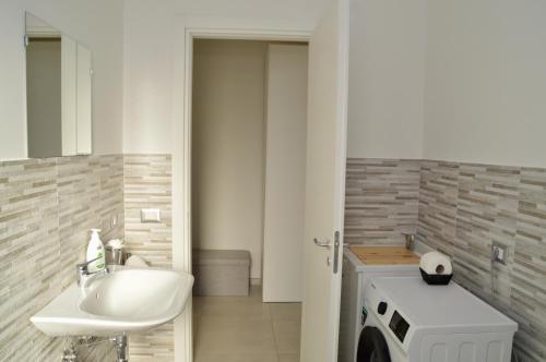 a bathroom with a sink and a washing machine at Home 13 in San Gregorio di Catania