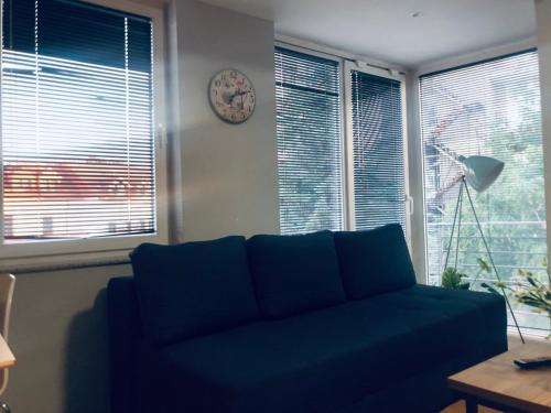 a blue couch in a living room with windows at Center lux Apartments in Bitola
