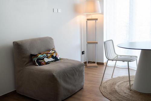 a living room with a chair and a table at Joya Apartment's - Milazzo in Milazzo