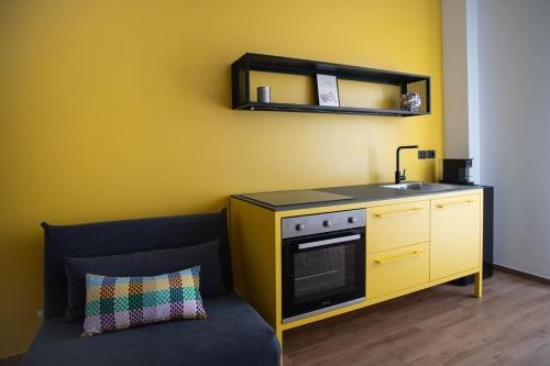 a kitchen with a stove and a sink and a couch at Joya Apartment's - Milazzo in Milazzo