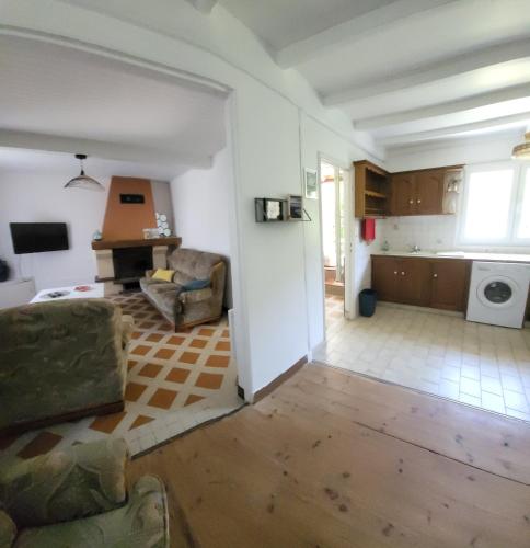 un salon avec un canapé et une cuisine dans l'établissement La maison rouge paisible maison de pays, à Saujon