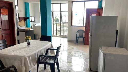 a room with a table with chairs and a refrigerator at Hospedaje Carliza II Backpackers in Puerto Ayora