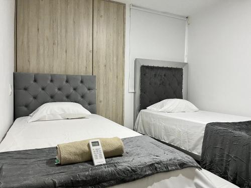 um quarto com duas camas com um telemóvel em Río Guatapuri y Confort Deluxe em Valledupar