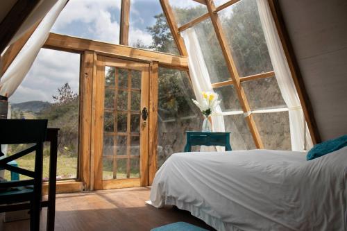 a bedroom with a bed and a large window at Destinos Exclusivos Patate in Patate