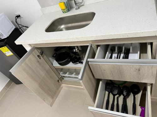 un bancone della cucina con lavandino e un cassetto con utensili di Río Guatapuri y Confort Deluxe a Valledupar