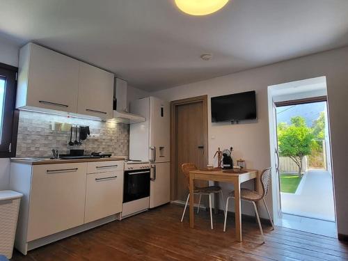 a kitchen with white cabinets and a table and a window at Saint George House in Ierapetra