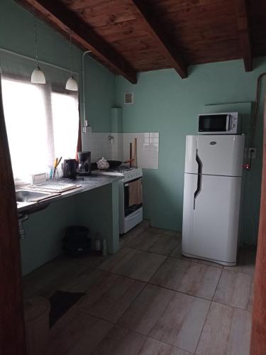 a kitchen with a white refrigerator and a window at "Donde brilla el sol" Casa Campo in Dina Huapi