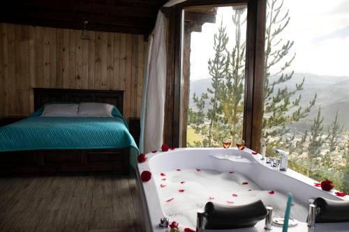 a bath tub in a room with a bed and a window at Destinos Exclusivos Patate in Patate