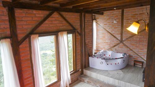 a bath tub sitting in a room with windows at Destinos Exclusivos Patate in Patate