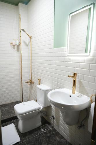 a white bathroom with a toilet and a sink at Hathor House in Cairo