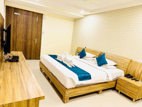 a bedroom with a bed with blue and white pillows at The Landmark Banjara Hills - Hyderabad in Hyderabad