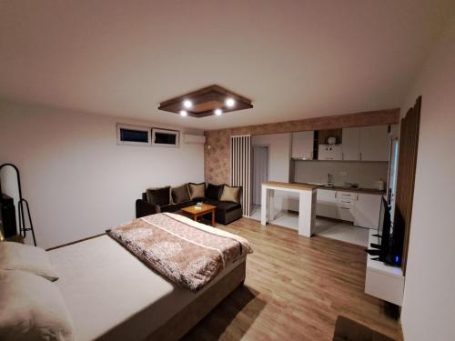 a bedroom with a bed and a living room at In apartman in Nikšić