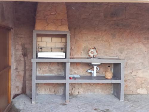 a gray shelf with a sink in a stone wall at Taliscas Stone Charm in Coimbra