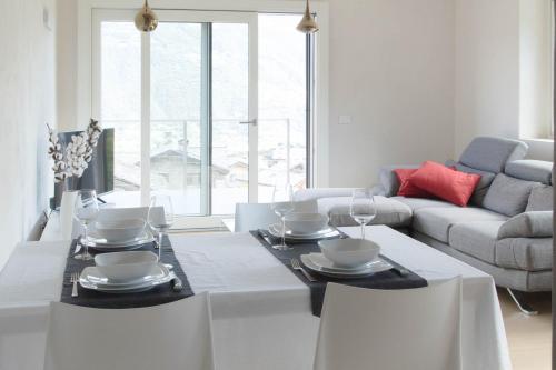 a white living room with a table and a couch at Style apartments VdA in Senin