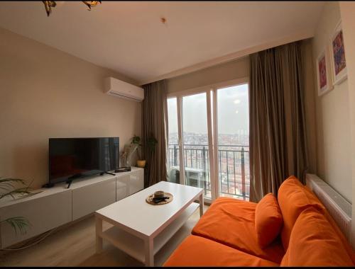 een woonkamer met een bank en een groot raam bij Kagıthane Gulmahal Residance 1+1 in Istanbul