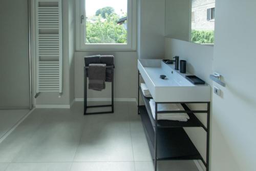 a white bathroom with a sink and a window at Style apartments VdA in Senin
