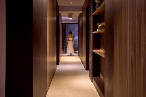 a woman in a dress walking down a hallway at SEA ZANTE Luxury Beachfront Retreat in Tragaki