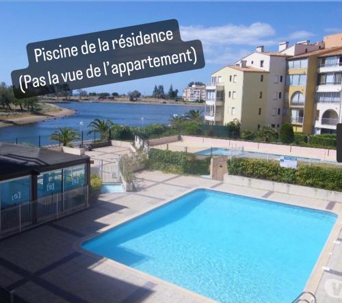 uma piscina azul em frente a alguns edifícios em Superbe appartement 6 personnes avec piscine secteur Richelieu, à 400m de la plage et à 650m du centre port em Cap d'Agde