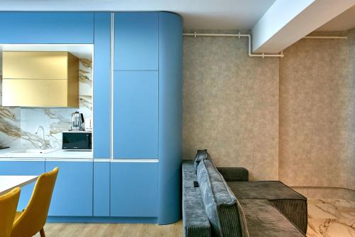 a kitchen with blue cabinets and a table and chairs at Unique Sea View Infinity Pool & Spa in Mamaia Nord