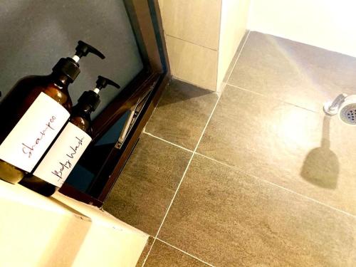 two bottles of wine sitting on the floor in a bathroom at The Address 2 in Nairobi
