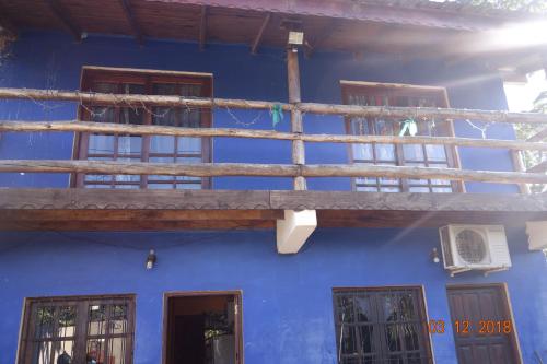 un edificio azul con balcón de madera en Apart Tres Fronteras en Puerto Iguazú