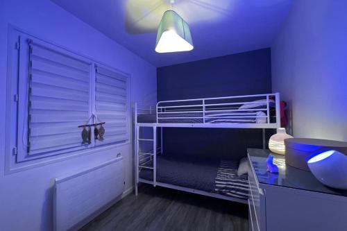- une chambre bleue avec des lits superposés et un bureau dans l'établissement Nice house with garden near the sea, à Brem-sur-Mer