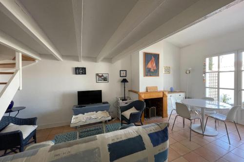 un salon avec un canapé et une table dans l'établissement 75m near the beach with garden and terrace, à La Flotte