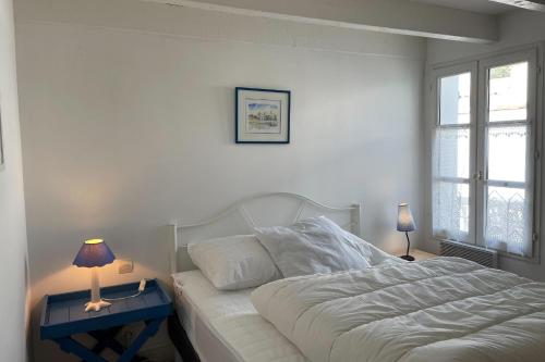 - une chambre avec un lit blanc et une table avec une lampe dans l'établissement 75m near the beach with garden and terrace, à La Flotte