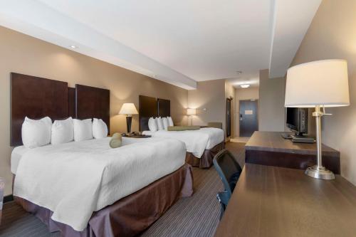 Habitación de hotel con 2 camas y TV en Best Western Plus Moose Jaw, en Moose Jaw