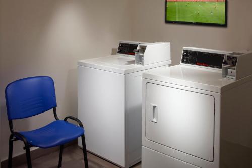 a blue chair sitting next to a washing machine at One Saltillo Aeropuerto in Saltillo