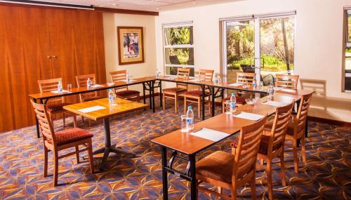 a conference room with wooden tables and chairs at StayEasy Pretoria in Pretoria
