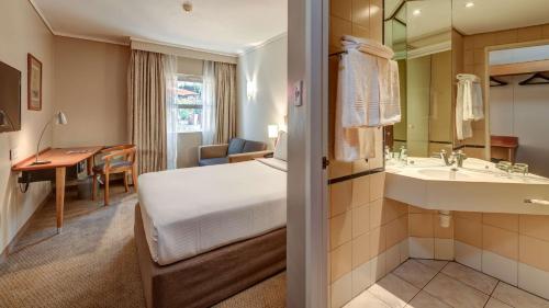 Habitación de hotel con cama y baño en StayEasy Pretoria en Pretoria