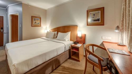 a hotel room with a bed and a desk at StayEasy Pretoria in Pretoria