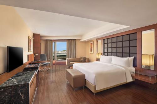 a hotel room with a large bed and a television at Radisson Blu Plaza Delhi Airport in New Delhi