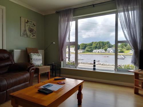 a living room with a table and a large window at Moorings Greenway in Newport