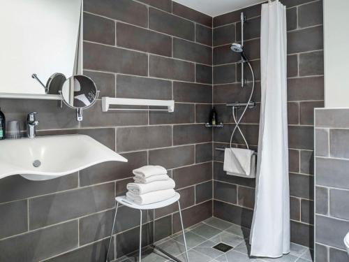 uma casa de banho com um lavatório e um chuveiro em Aparthotel Adagio Glasgow Central em Glasgow