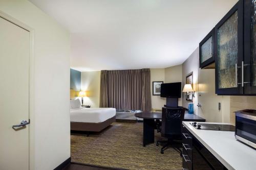 a hotel room with a bed and a kitchen at Sonesta Simply Suites St Louis Earth City in Earth City