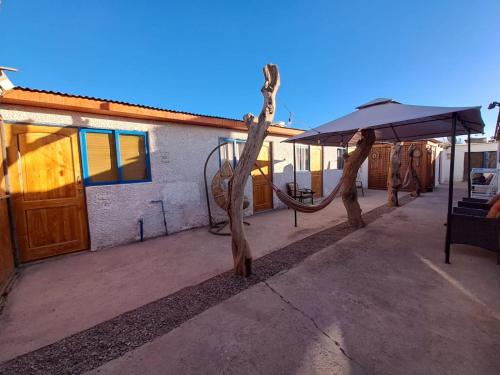 a patio with a swing set and an umbrella at CASA TAMBO in San Pedro de Atacama