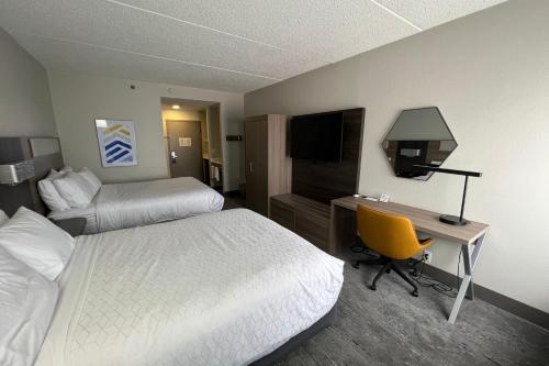 a hotel room with two beds and a desk with a computer at Holiday Inn Express Harrisburg I-81 - Hershey By IHG in Manadahill