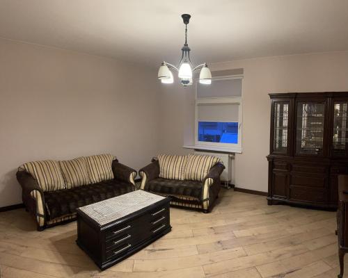 a living room with two couches and a table at Gintautas apartment in Šiauliai
