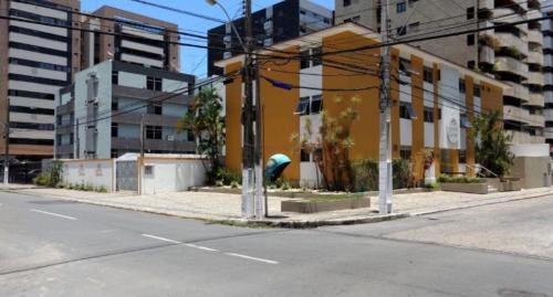 una calle vacía con un edificio amarillo a un lado de la carretera en Hotel Porto Grande, en Maceió