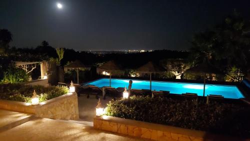 a swimming pool at night with lights at Retiro da Janela in Boliqueime