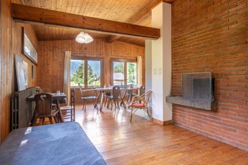 - un salon avec un mur en briques, une table et des chaises dans l'établissement Rustic chalet with garden in Chamonix, à Chamonix-Mont-Blanc
