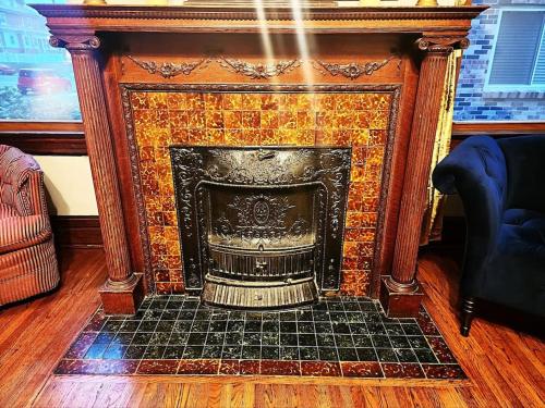 a fireplace in a living room with a mosaic tile at Cozy Victorian w/4-Car Garage! in Omaha