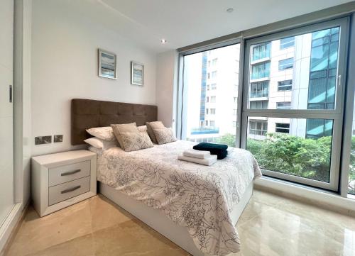 a bedroom with a bed and a large window at Luxury 1 Bed Apt - City Suites Ocean Spa Plaza in Gibraltar