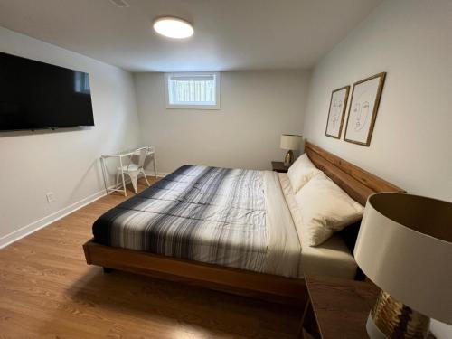 a bedroom with a bed and a flat screen tv at Letitia Heights !B Spacious and Quiet Private Bedroom with Shared Bathroom in Barrie