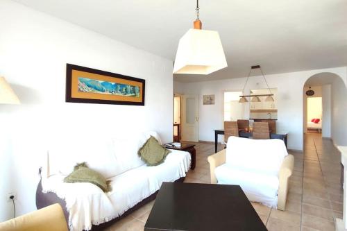 een woonkamer met twee witte banken en een tafel bij Terraza con vistas en Alcaidesa in Alcaidesa