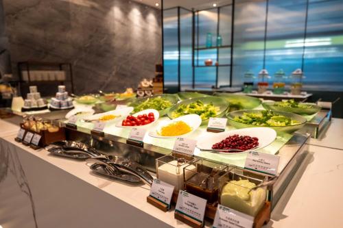 a buffet with many plates of food on a counter at Holiday Inn Changchun Oriental Plaza by IHG in Changchun