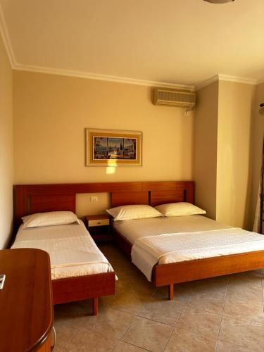 a bedroom with two beds and a table at AMI apartament in Vlorë
