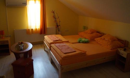 a bedroom with two beds and a window at Tó- Party Panoráma Panzió & Wellness in Kiszombor